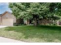 Inviting exterior of brick home with mature tree providing ample shade and attached garage at 12631 W Dakota Dr, Lakewood, CO 80228
