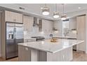Modern kitchen with stainless steel appliances, a large center island, and designer lighting at 2350 Tremont Pl # 13, Denver, CO 80205