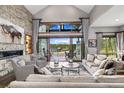 The inviting living room has a stone fireplace, comfortable seating, and large windows showcasing amazing mountain views at 60 Barton Ridge Dr, Breckenridge, CO 80424