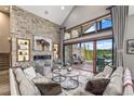 This living room features a stone accent wall, fireplace, and expansive windows offering stunning mountain views at 60 Barton Ridge Dr, Breckenridge, CO 80424