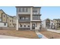 Contemporary three-story home with gray siding, stone accents, balcony, and landscaped front yard at 8846 Waterleaf Ln, Littleton, CO 80125
