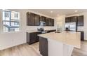 Modern kitchen featuring sleek dark cabinets, stainless steel appliances, and a large center island at 8846 Waterleaf Ln, Littleton, CO 80125