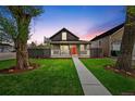 Charming two-story home with a well-maintained lawn and inviting red door at 800 S Krameria St, Denver, CO 80224