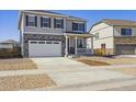 Two-story home showcasing stone accents, a two-car garage, and a charming front porch at 245 S Vandriver Way, Aurora, CO 80018
