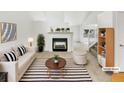 Bright, staged living room with a fireplace, striped rug, and comfortable seating creating an inviting atmosphere at 124 High Country Trl, Lafayette, CO 80026