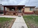 Quaint brick home featuring a cozy front porch with pillars and a short walkway to the front door at 5363 W 4Th Ave, Lakewood, CO 80226