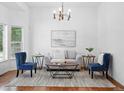 Inviting living room featuring stylish furniture, hardwood floors, and a modern chandelier at 2130 Chestnut Cir, Erie, CO 80516