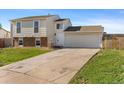 Split level home with a two-car garage and a spacious driveway, showing a front lawn at 1488 S Andes Way, Aurora, CO 80017
