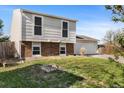 Split level home showing the exterior features of siding, brick accents, a two-car garage, and a front lawn at 1488 S Andes Way, Aurora, CO 80017