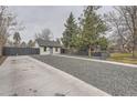 Exterior view of a single-story home featuring a large yard and privacy fence in a neighborhood setting at 1525 Roslyn St, Denver, CO 80220