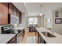 Contemporary kitchen with dark wood cabinetry, stainless appliances, and a view of the dining area at 2426 Welton St, Denver, CO 80205