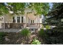 Inviting front porch with stone pillars and lush landscaping creates a welcoming entrance to the home at 5309 Mining Camp Trl, Parker, CO 80134