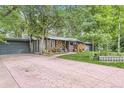 Inviting home with a long driveway and mature trees offering shade and curb appeal at 2220 Lee St, Lakewood, CO 80215