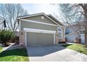Attractive home with brick accents, well-kept lawn, and a convenient two-car garage at 1374 Spotted Owl Way, Highlands Ranch, CO 80129