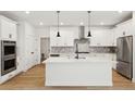 Modern kitchen with white cabinets, herringbone backsplash, and large island at 42974 Colonial Trl, Elizabeth, CO 80107