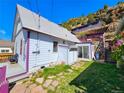 A private backyard offers a tranquil retreat with a patio and unique staircase leading to the upper levels at 1716 Virginia St, Idaho Springs, CO 80452