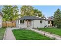 Charming home featuring a well-kept lawn, front yard landscaping, and an inviting outdoor seating area at 3541 Eudora St, Denver, CO 80207