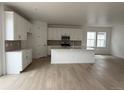 Bright, all-white kitchen featuring a large island, modern appliances, and sleek cabinetry, perfect for culinary enthusiasts at 7267 Prairie Sage Pl, Littleton, CO 80125