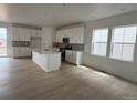 Bright, all-white kitchen featuring a large island, modern appliances, and sleek cabinetry, with natural light from the windows at 7267 Prairie Sage Pl, Littleton, CO 80125