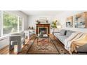 Bright living room with hardwood floors, stylish furnishings, and a cozy fireplace at 3054 S Raleigh St, Denver, CO 80236