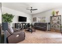 Comfortable living room features leather furniture, a ceiling fan, media center, and plush carpeting at 9535 Dexter Ln, Thornton, CO 80229