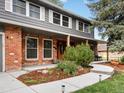 Close-up of the home's brick exterior and landscaped walkway to the front door at 5845 W Portland Dr, Littleton, CO 80128