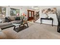 Cozy living room with plush seating, a large window, and staircase at 5845 W Portland Dr, Littleton, CO 80128