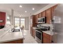 Well-lit kitchen with stainless steel appliances, wooden cabinets and adjacent dining area at 3577 Molly Cir, Broomfield, CO 80023