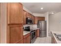 Functional kitchen with wooden cabinetry, stainless steel appliances, and tiled flooring at 3577 Molly Cir, Broomfield, CO 80023