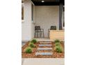 Welcoming front porch featuring modern chairs and a serene garden setting with stone pathways at 4395 Newland St, Wheat Ridge, CO 80033
