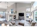 Spacious living room with soaring ceilings, a cozy fireplace, large windows, and stylish neutral decor at 12430 S Downy Creek Ct, Parker, CO 80134