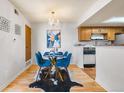 Charming dining room with a glass table, blue chairs, and chandelier lighting at 942 S Walden St # 204, Aurora, CO 80017