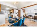 Open dining room with modern glass table and stylish blue chairs near the living area at 942 S Walden St # 204, Aurora, CO 80017