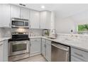 Bright kitchen featuring stainless steel appliances, white cabinets, and stylish backsplash at 2017 N Fork Dr, Lafayette, CO 80026