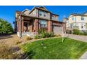 Beautiful brick home with covered porch and a well-maintained lawn and landscaping at 27029 E Irish Pl, Aurora, CO 80016
