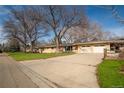 Single-story home with a well-maintained lawn, attached garage, and plenty of parking space at 430 Long View Ct, Longmont, CO 80501