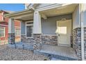 Inviting front porch featuring stone pillars and a cozy entrance to welcome you home at 17962 E 103Rd Ave, Commerce City, CO 80022