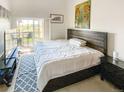 Bedroom features a wooden headboard, patterned rug, and access to the balcony at 9481 E Mansfield Ave # 305, Aurora, CO 80014