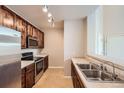 Well-lit kitchen features stainless steel appliances, stone countertops, and wood cabinetry at 9481 E Mansfield Ave # 305, Aurora, CO 80014