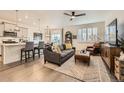 Open-concept living room featuring hardwood floors, a ceiling fan, and bright, natural light at 16135 Mountain Flax Dr, Monument, CO 80132