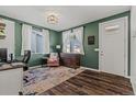 Bright home office with green walls, hardwood floors, and ample natural light at 27882 E 9Th Dr, Aurora, CO 80018