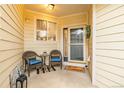 Inviting covered porch with chairs and a welcome mat, perfect for enjoying the outdoors at 13545 W 62Nd Ln, Arvada, CO 80004