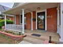 Inviting front porch with brick accents, white columns, and a cozy seating area at 482 S Logan St, Denver, CO 80209