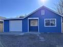 Charming blue home with an attached garage, bright exterior, and well-maintained gravel yard at 530 Hickory St, Hudson, CO 80642
