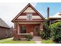 Charming brick home with a covered front porch, decorative roof, and well-maintained landscaping at 461 S Sherman St, Denver, CO 80209