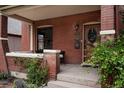 Covered brick front porch with elegant wood door and well-maintained landscaping at 461 S Sherman St, Denver, CO 80209