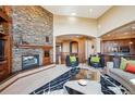 Living room with stone fireplace and view into kitchen area at 16134 Sandstone Dr, Morrison, CO 80465