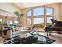 Bright living room with floor to ceiling windows and a grand piano at 16134 Sandstone Dr, Morrison, CO 80465
