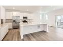 Modern kitchen with stainless steel appliances, white cabinets, and a large center island at 2138 S Haleyville Way, Aurora, CO 80018