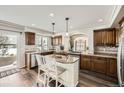 Bright kitchen features granite counters, wooden cabinets, stainless steel appliances, and breakfast bar at 5072 Cathay St, Denver, CO 80249